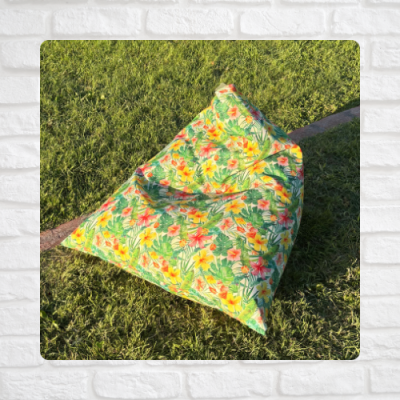 Puff colorido com padrão floral sobre relvado verde
