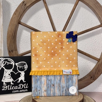 Capa para livro ou agenda em tecido amarelo com bolinhas brancas e detalhe madeira azul