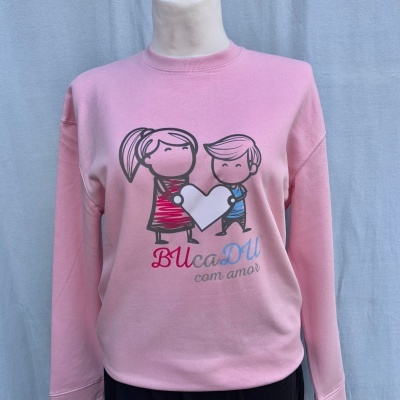 Sweatshirt rosa com ilustração de menino e menina a segurar coração e texto BUcaDU com amor