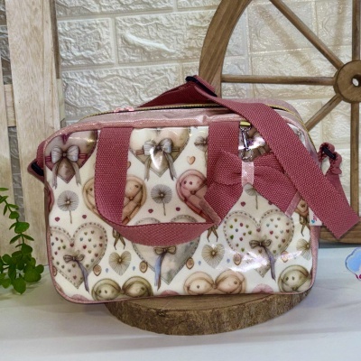 Mala de ombro cor creme com padrão de corações e alças rosa