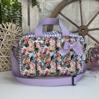 Mala com pássaros coloridos, alças lilás e laço decorativo