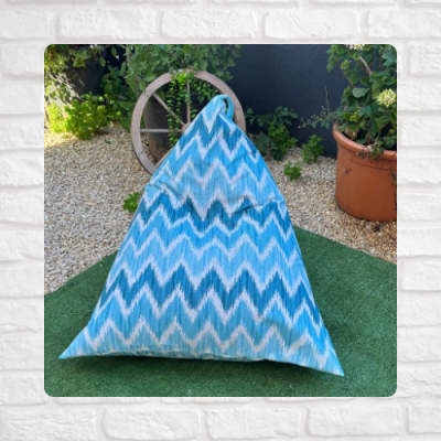 Almofada triangular azul e branca em jardim
