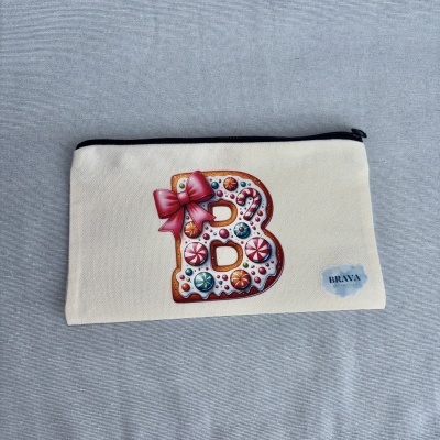 Estojo branco com fecho preto e letra B decorativa estilo biscoito colorido