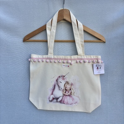 Bolsa em tecido cru com pompons rosa e ilustração de unicórnio e menina