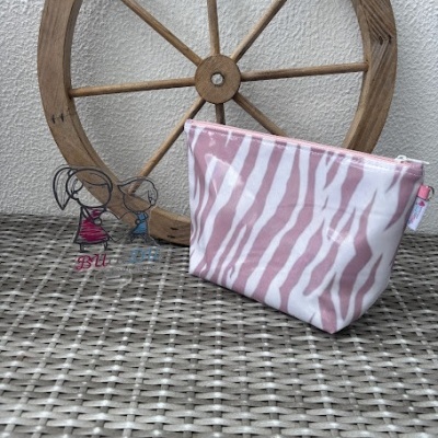 Bolsa rosa com padrão de zebra e roda de madeira em fundo