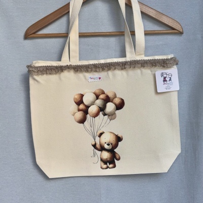 Sacola bege com estampa de ursinho e balões e detalhe de renda na parte superior