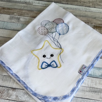 Fralda branca com bordado de estrela, balões coloridos e borda xadrez azul.