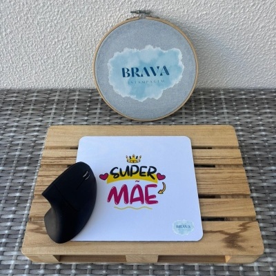 Tapete de rato branco com texto colorido e rato preto ao lado sobre base de madeira