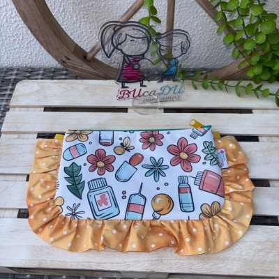 Estojos coloridos com padrão floral e medicamentos com babado amarelo e fecho de zíper
