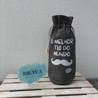 Saco de tecido cinzento com texto e bigode branco junto a suporte azul com texto BRAVA ESTAMPAGEM