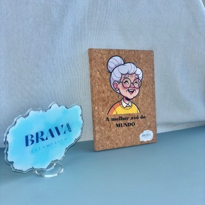 Placa de cortiça com ilustração de avó e texto junto a acrílico azul com texto BRAVA ESTAMPAGEM
