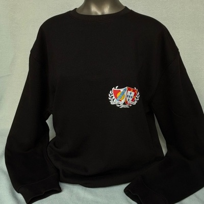 Sweatshirt preta com escudo colorido no peito sobre fundo cinzento claro