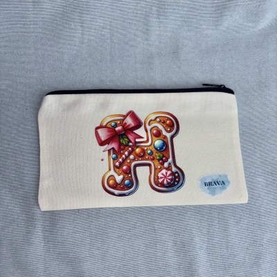 Estojo com ilustração de biscoito em forma de H e fecho preto