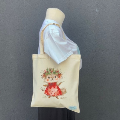 Saco de tecido bege com estampa de ouriço vestido com saia vermelha e detalhes de vegetação