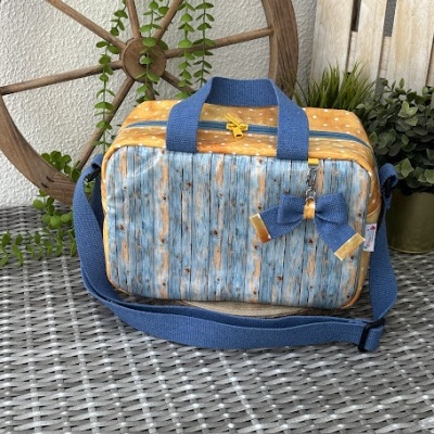 Bolsa azul e amarela com padrão imitando madeira envelhecida e detalhes amarelos com bolinhas brancas