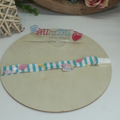 Pulseira colorida de tecido com fecho branco sobre base de madeira clara