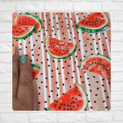 Tecido com padrão de fatias de melancia e fundo listrado bege com mão à esquerda