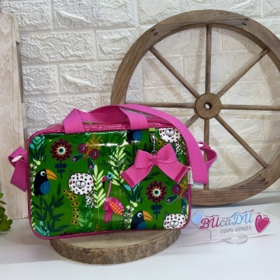 Mala colorida com padrão de animais e laço rosa