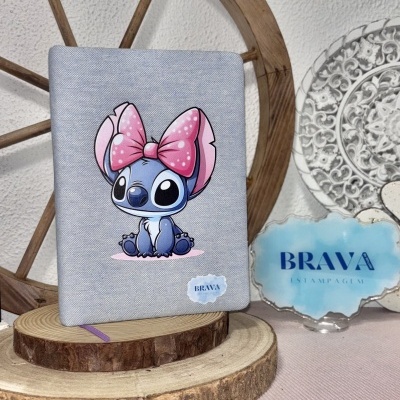 Capa de caderno cinza com ilustração de personagem azul e laço rosa