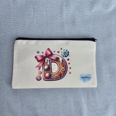 Estojo de tecido com desenho de biscoito em forma da letra D e balas coloridas