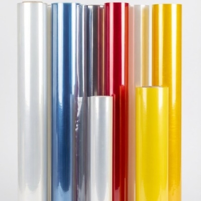 Seis rolos de película plástica colorida em diversas cores sobre superfície branca.