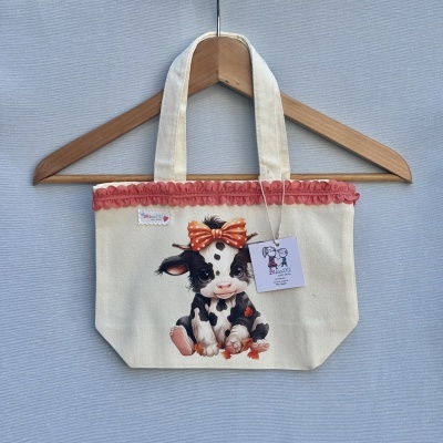 Mala de tecido creme com ilustração de vaquinha com laço vermelho e folhas de outono