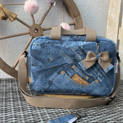 Mala azul padrão ganga com laço castanho em superfície de rattan cinzento