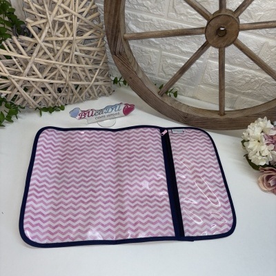 Organizador rosa e branco com padrão zigzag e fecho de correr, em fundo branco com decoração rústica