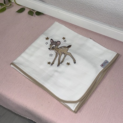 Manta branca com borda bege e veado bordado com estrelas