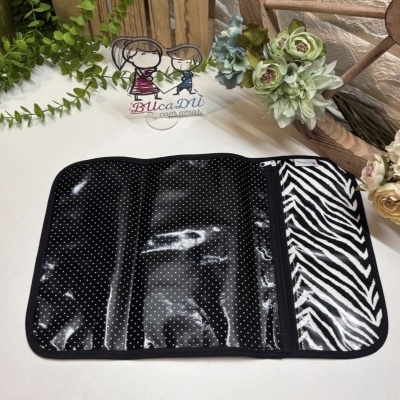 Organizador plástico preto com bolinhas brancas e padrão zebra sobre superfície branca