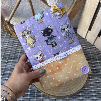 Capa colorida com padrão de gatos vestidos e detalhes decorativos.