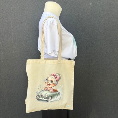 Saco de pano bege com estampa de senhora caricata a conduzir carro clássico verde-água