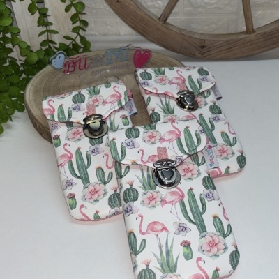 Carteiras brancas com padrão de cactos e flamingos em mesa branca com decoração de madeira e plantas