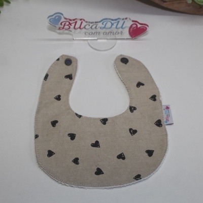 Babete bege com corações pretos e fecho de pressão