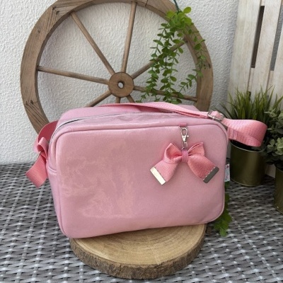 Bolsa rosa de veludo com laço e fundo decorativo com volante e plantas