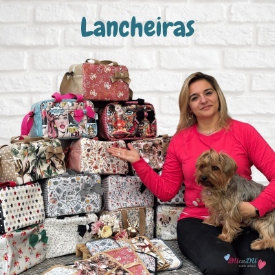 Mala feminina para lanche com padrões diferentes e laços, junto com mulher e cão diante de parede branca