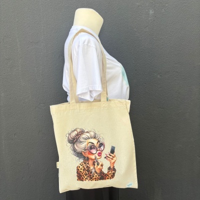 Mala tote bege com ilustração de mulher idosa a aplicar batom.
