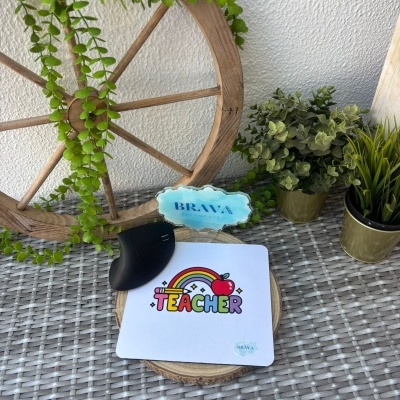 Tapete de rato branco com a palavra TEACHER colorida, roda de madeira decorativa com planta e vasos com plantas