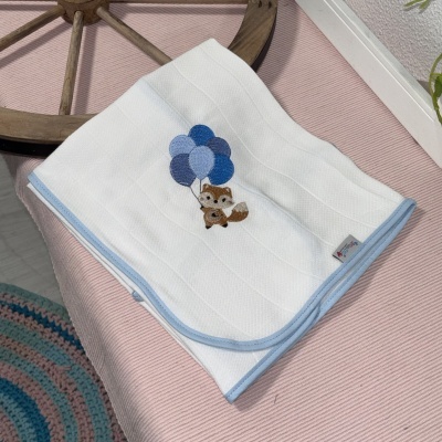 Manta branca com bordado de raposa e balões azuis