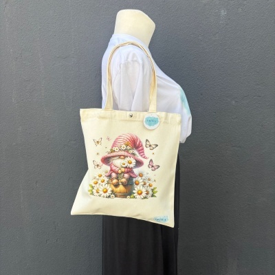 Mala de tecido bege com ilustração de gnomo, flores e borboletas