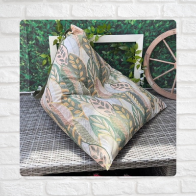 Almofada decorativa com padrão de folhas em tons suaves em ambiente de varanda