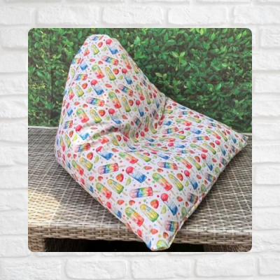 Almofada triangular colorida para encosto com padrão de gelados e pirulitos