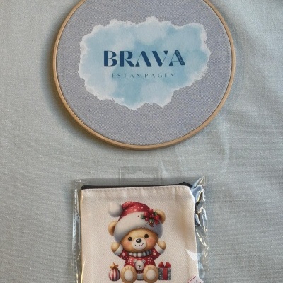 Bastidor de madeira com estampa BRAVA ESTAMPAGEM e bolsa com desenho de urso de Natal.