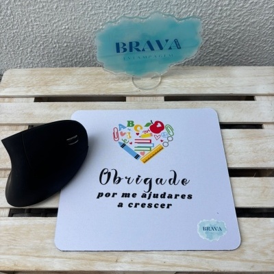Tapete de rato branco com design e texto, rato preto e placa azul de acrílico sobre superfície de madeira