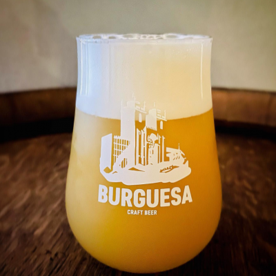 Copo de vidro com cerveja artesanal BurGUESA e espuma branca