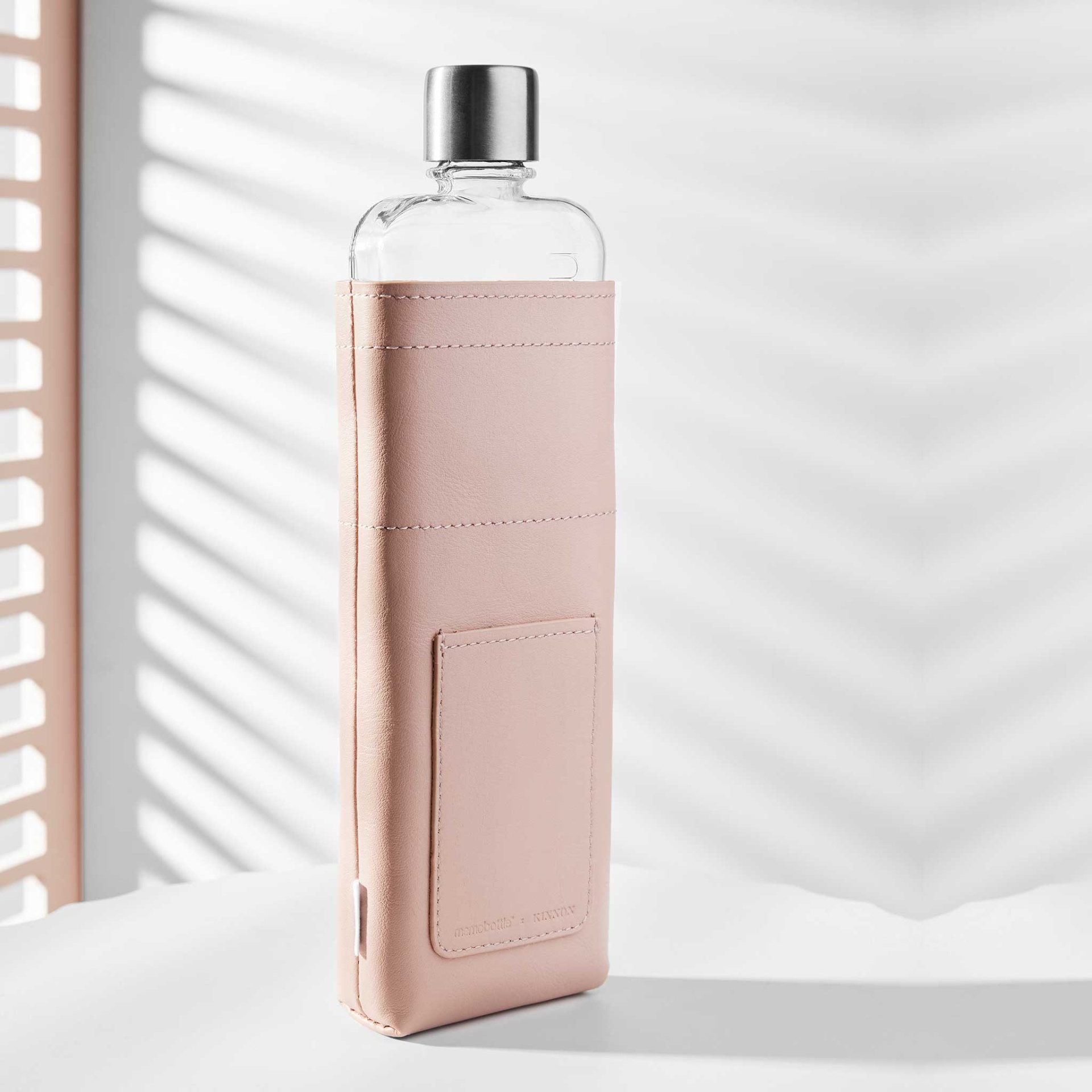 Slim Nude Leather Sleeve memobottle Garrafa de vidro com capa cor-de-rosa e tampa metálica sobre fundo branco