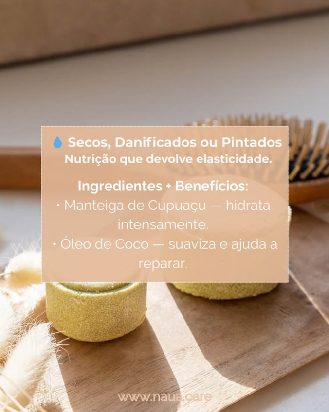 Champô Sólido NAUA Cabelos Secos/Pintados/Danificados Duas barras sólidas amarelas de champô sobre uma base de madeira com escova de cabelo de madeira ao fundo e texto informativo em português.