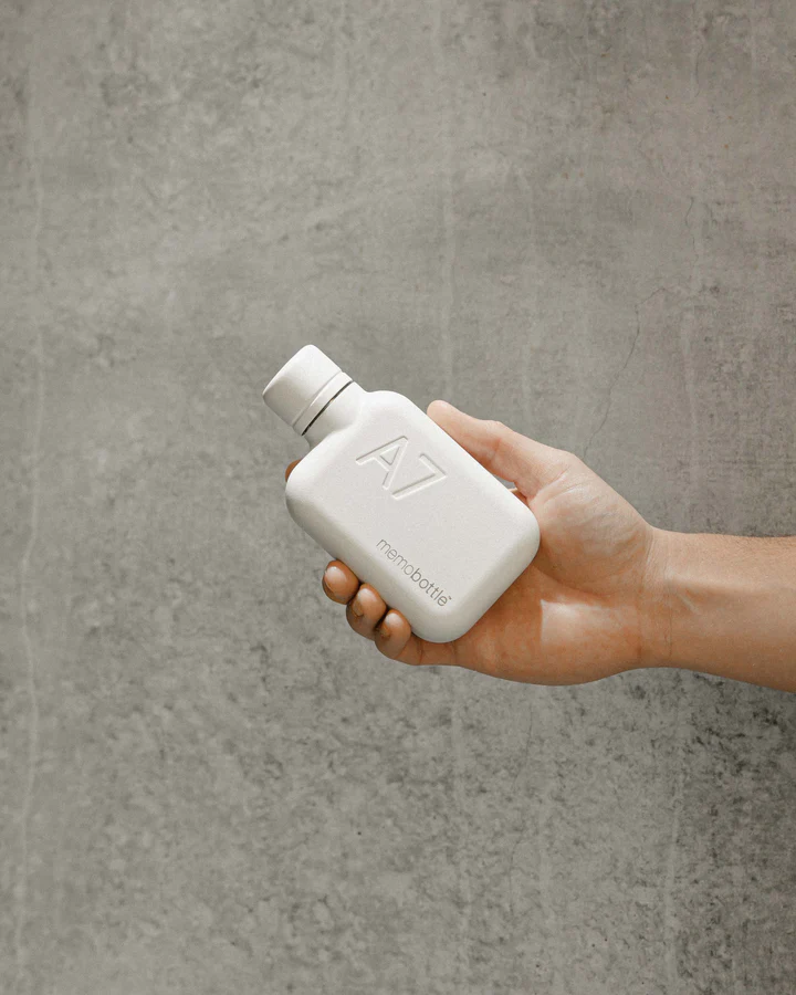 A7 memobottle Stainless Steel - WHITE Frasco branco compacto A7 memobottle na mão com fundo cinzento