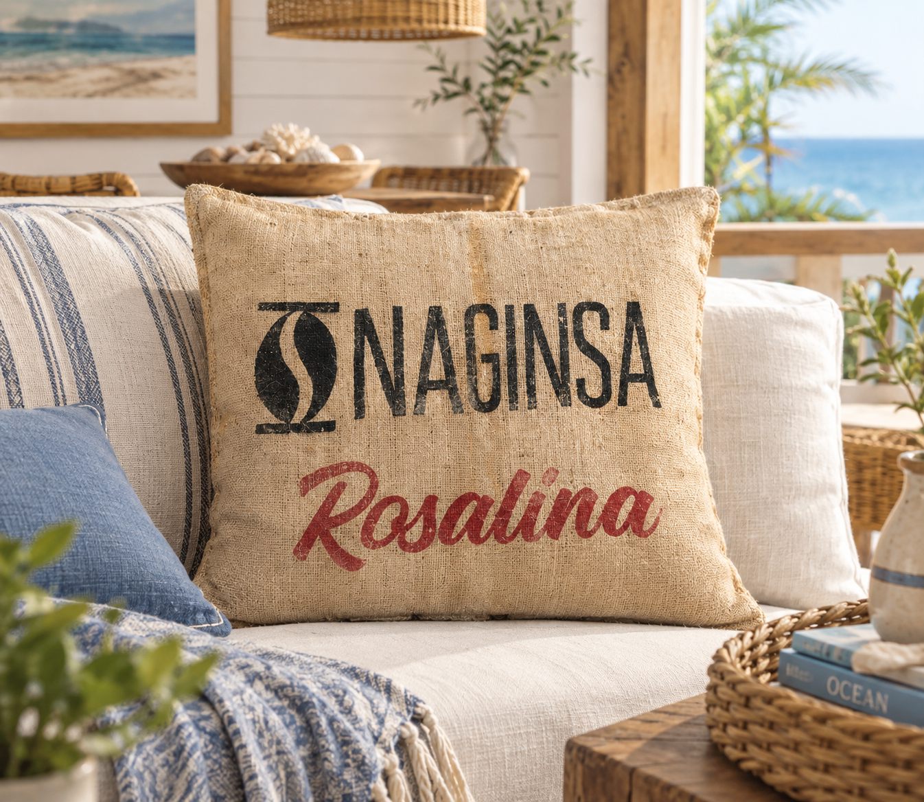 Almofada em Serapilheira Reciclada - 60X50CM Almofada decorativa bege com texto NAGINSA Rosalina num sofá com almofadas azul e bege