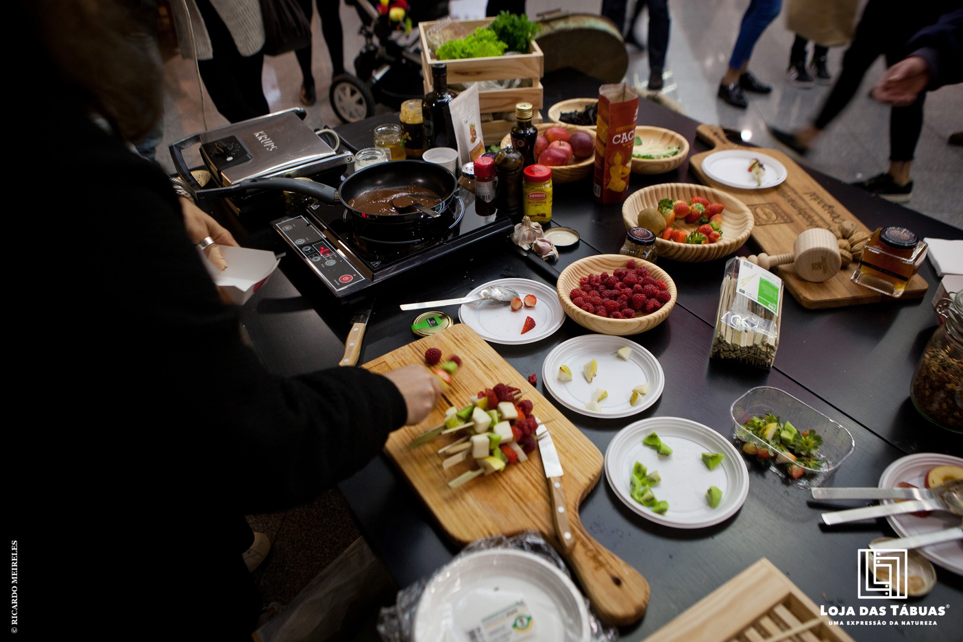 Bancada de cozinha com utensílios, frutos e vegetais para preparação culinária